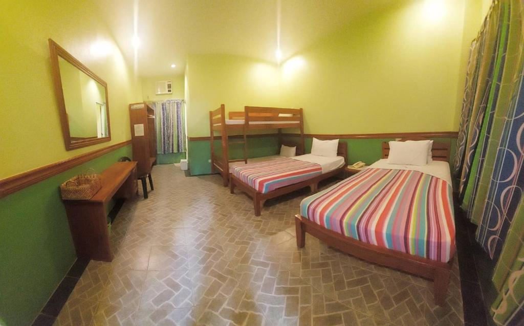 Habitación pequeña con 2 camas y espejo. en Sea Forest Resort en Sibulan