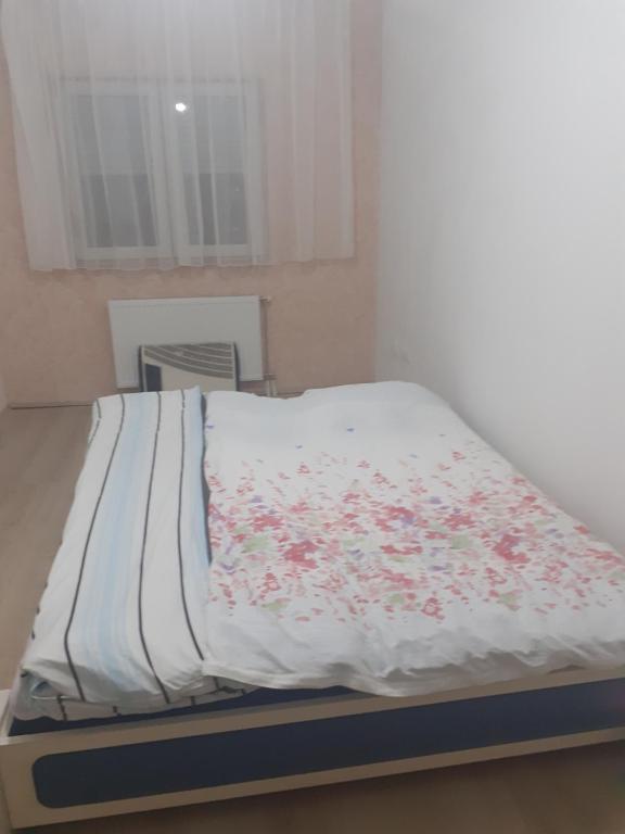 ein Bett mit einer weißen Decke mit Blumen drauf in der Unterkunft Dunav in Smederevo