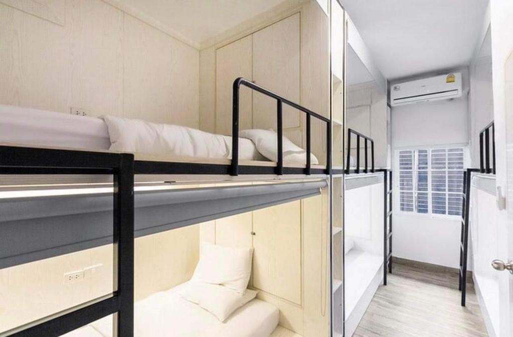 バンコクにあるComfy Crib Hostelの二段ベッド2組、バスルームが備わるドミトリールームのベッド1台分です。