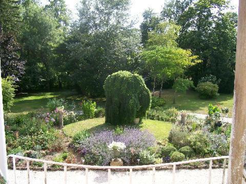 a garden with a bush in the middle at Manoir Angle in Blanzay-sur-Boutonne