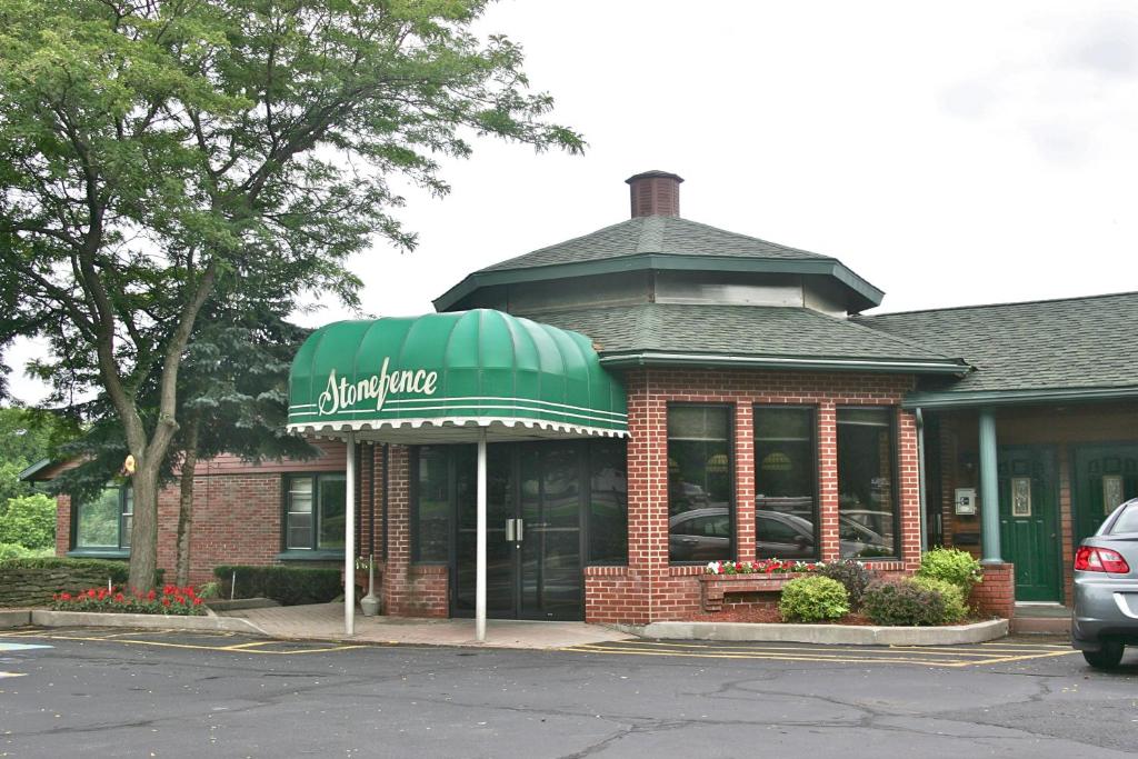 a building with a green awning on a street at Stone Fence Resort in Ogdensburg