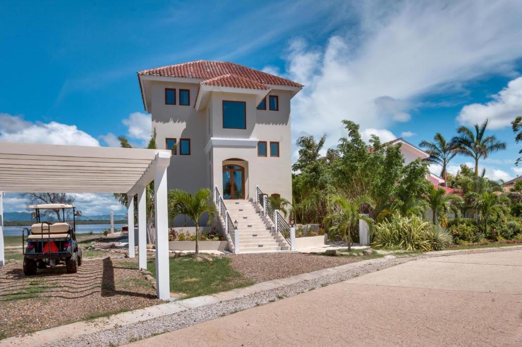 une maison sur la plage avec une voiturette de golf en face dans l'établissement Laguna Gecko Villa, à Placencia