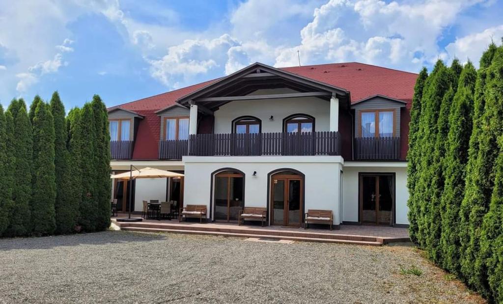 une grande maison avec un toit rouge dans l'établissement Pensiunea Eden Éden Panzió, à Odorheiu Secuiesc