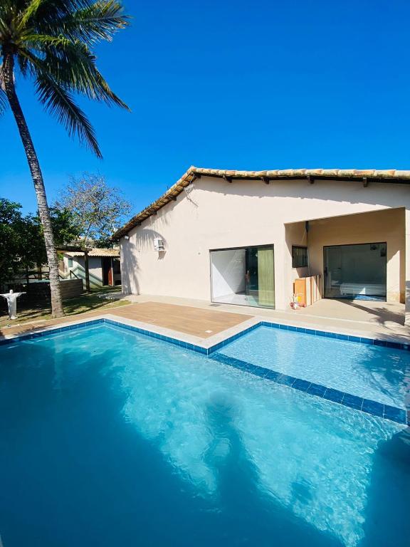 a swimming pool in front of a house at Casa com piscina e jacuzzi in Cabo Frio