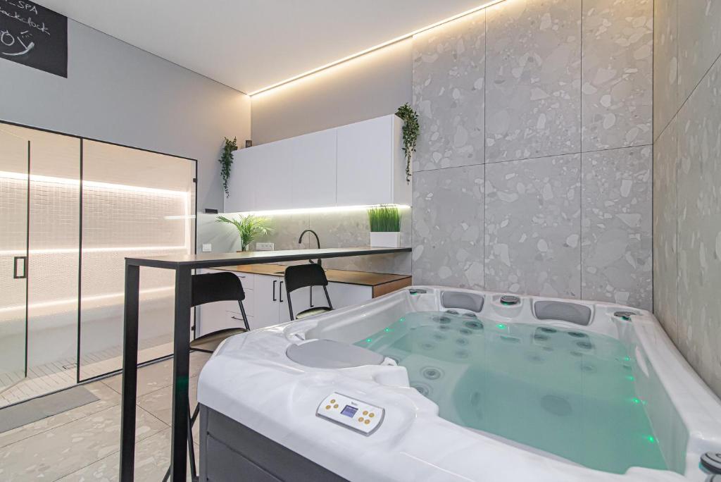 a bathroom with a bath tub with a table and chairs at Secret SPA in Vilnius