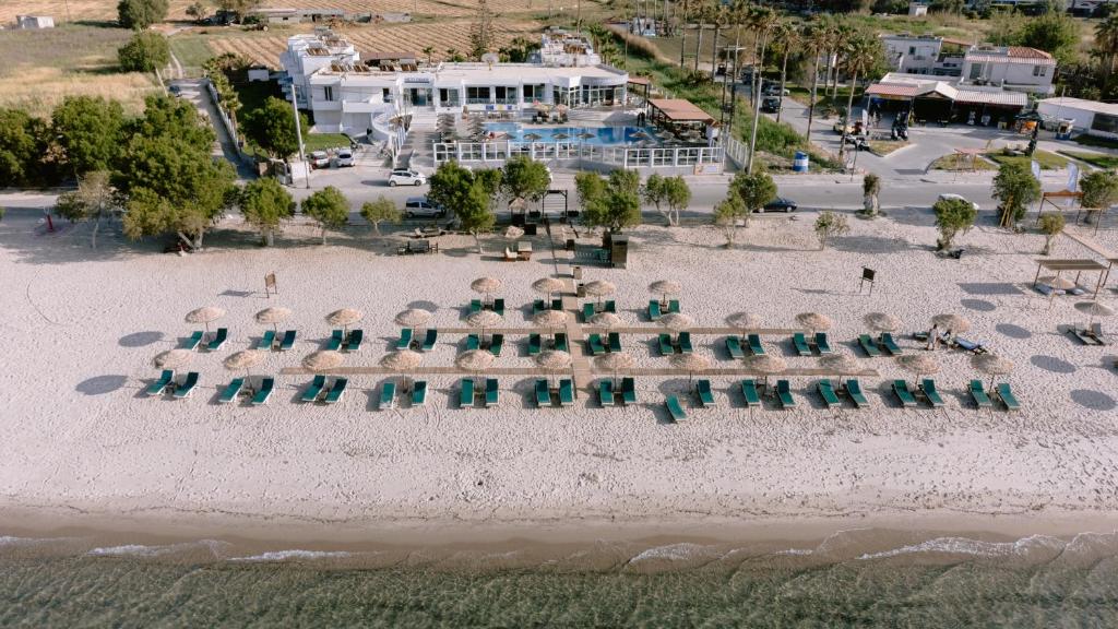 een luchtzicht op een strand met stoelen en parasols bij Akti Dimis Hotel in Tigaki