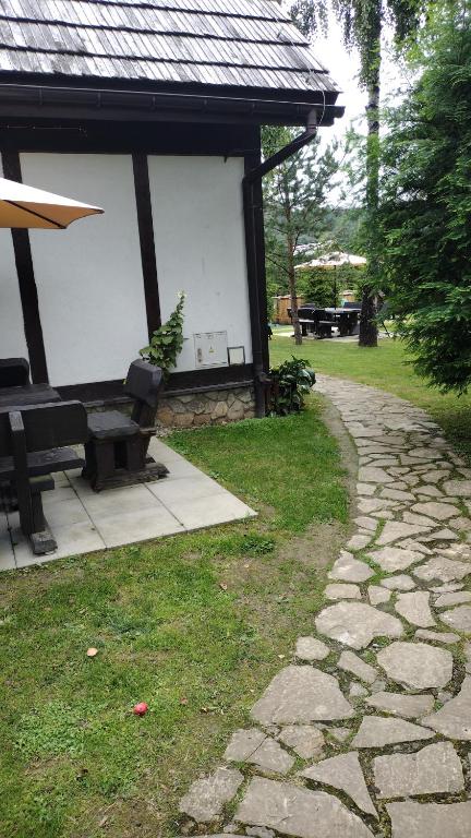 um pavilhão com um banco e uma passagem de pedra em Ośrodek na zakręcie em Ustrzyki Dolne