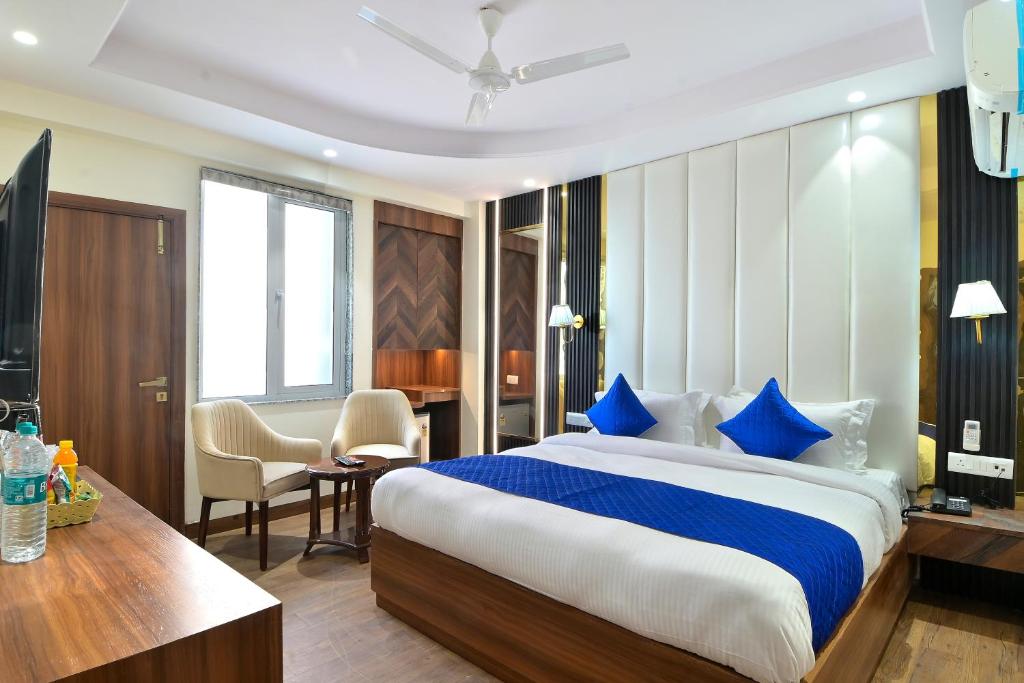 a hotel room with a large bed and a desk at The Saina International Delhi - By La Exito Hotels in New Delhi
