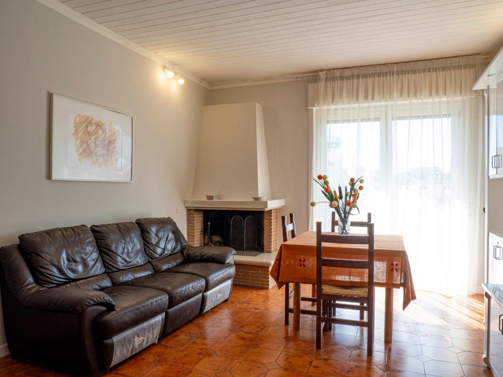 een woonkamer met een leren bank en een tafel bij Casa Verdi Colli in Montecastrilli