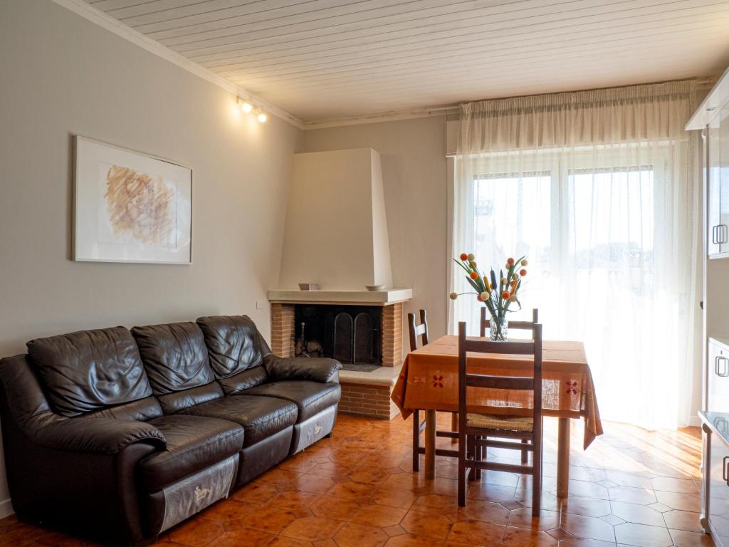 a living room with a leather couch and a table at Casa Verdi Colli in Montecastrilli