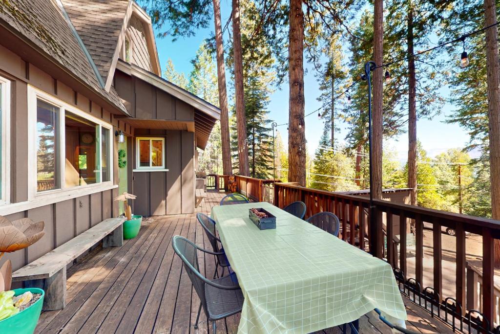 a wooden deck with a table and chairs on it at Fernwood in Shaver Lake