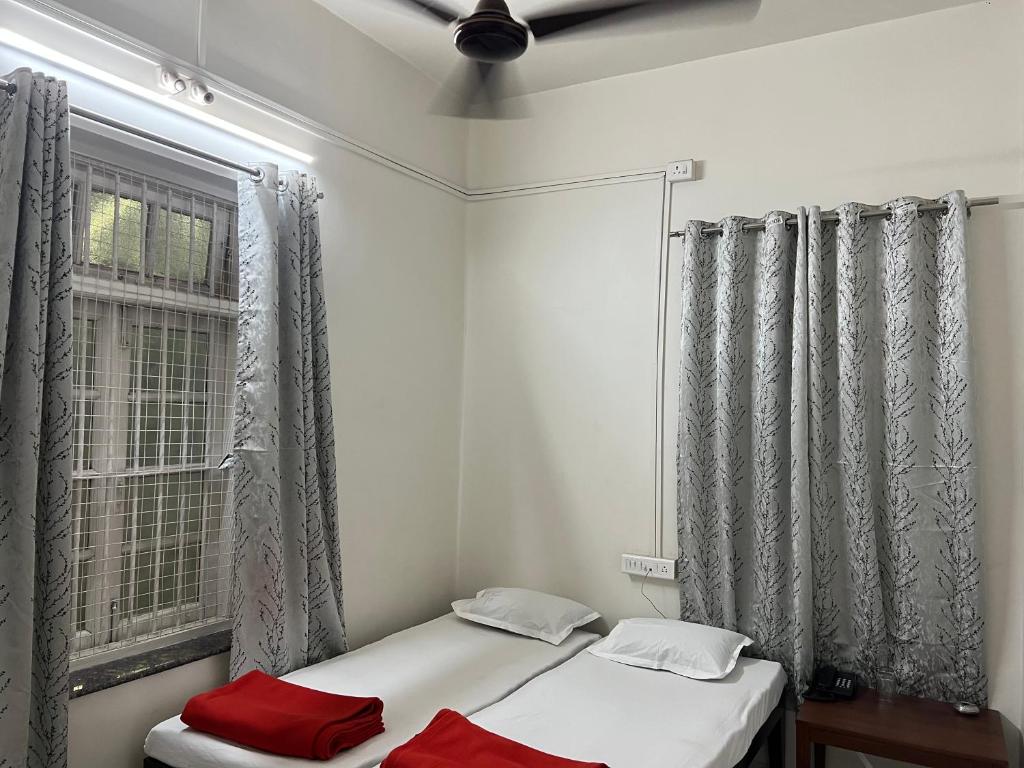 - une chambre avec 2 lits et une fenêtre dans l'établissement Hotel Laxminarayan Niwas, à Pune