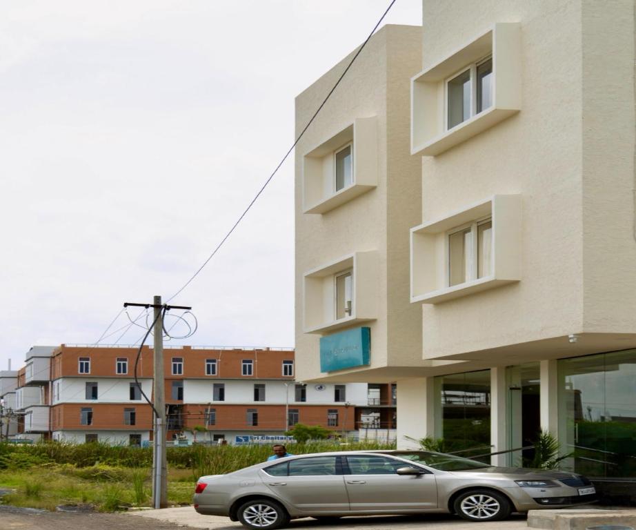 een auto geparkeerd voor een gebouw bij FLORA PAVILLION in Chennai