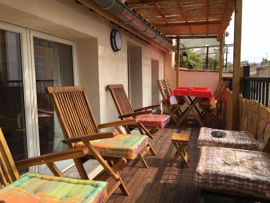 - un groupe de chaises et une table sur une terrasse couverte dans l'établissement FLC - Cannebière-Clim-Large Terace-Max 4 guests, à Marseille