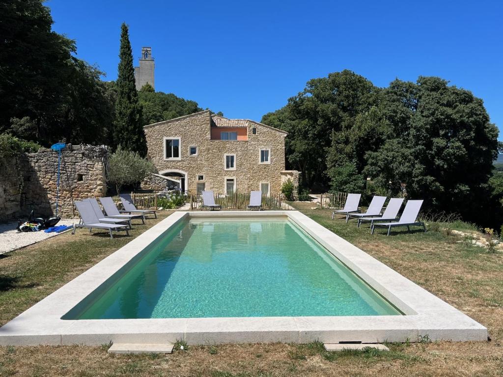 - une piscine en face d'une maison en pierre dans l'établissement Havre de paix à Chamaret - Gite de charme en Drôme Provençale, à Chamaret
