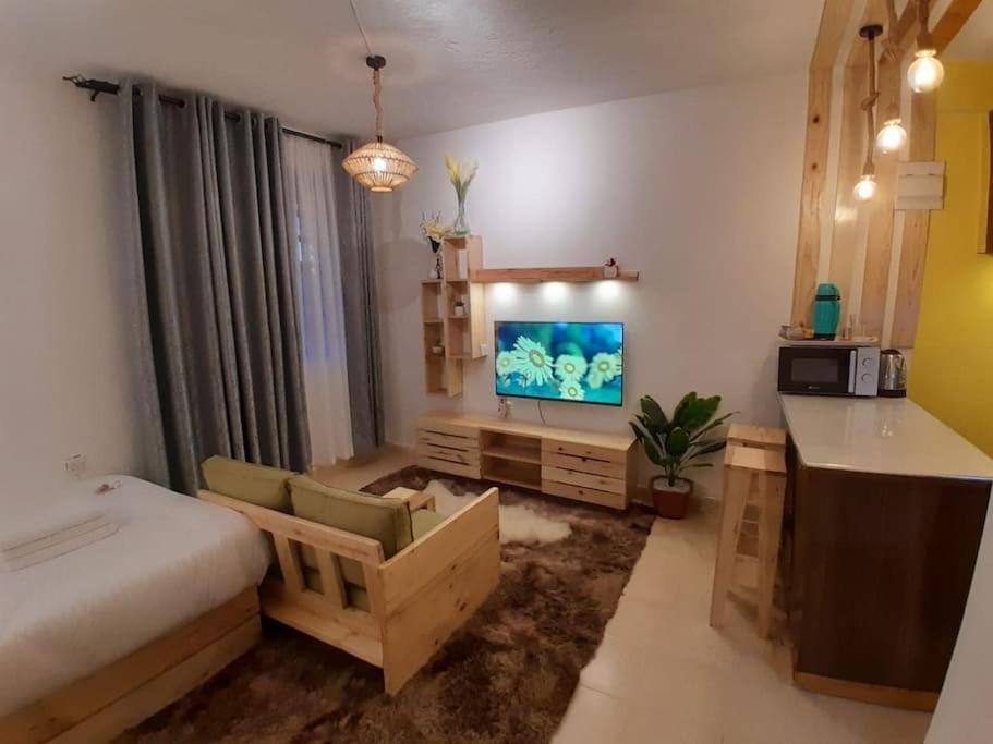 sypialnia z łóżkiem, telewizorem i biurkiem w obiekcie EnN 2 Lovely Premium Apartment w mieście Bungoma