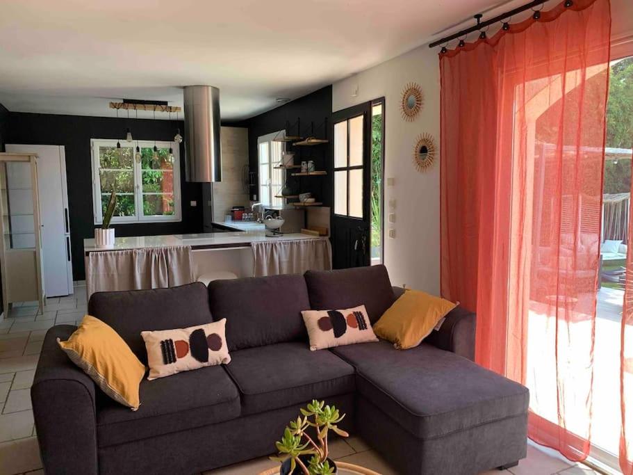 a living room with a couch and a kitchen at La villa Pausa en Drôme provençale in Montboucher-sur-Jabron