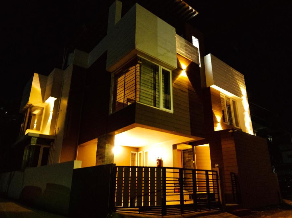 a house lit up at night with lights at Mellow Mount Private Homestay in Ooty