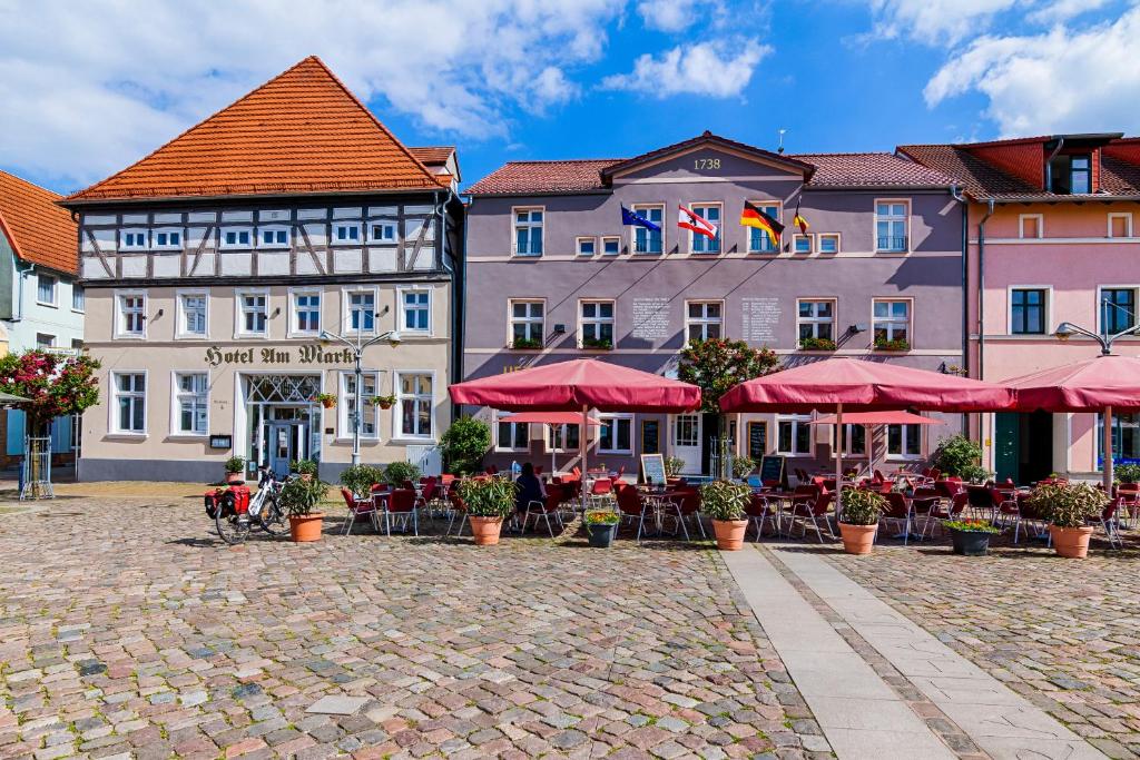 a group of buildings with tables and umbrellas at Hotel Am Markt & Brauhaus Stadtkrug in Ueckermünde