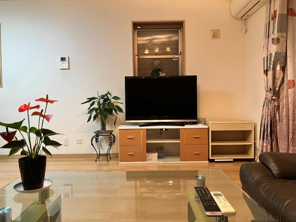 un salon avec une télévision à écran plat sur un centre de divertissement dans l'établissement 新規OPEN8割！1棟貸切・10名可能！秋葉原まで13分、新宿まで32分／スカイツリー近く, à Tokyo