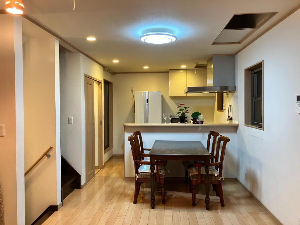 a kitchen with a table and chairs in a room at 新規OPEN8割！1棟貸切・10名可能！秋葉原まで13分、新宿まで32分／スカイツリー近く in Tokyo