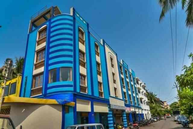 a blue and white building on the side of a street at HOTEL AVISHA Residency in Marmagao