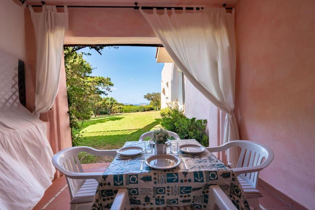a table and chairs in a room with a window at [PORTO CERVO] Accanto alla spiaggia & vista Mare in Porto Cervo