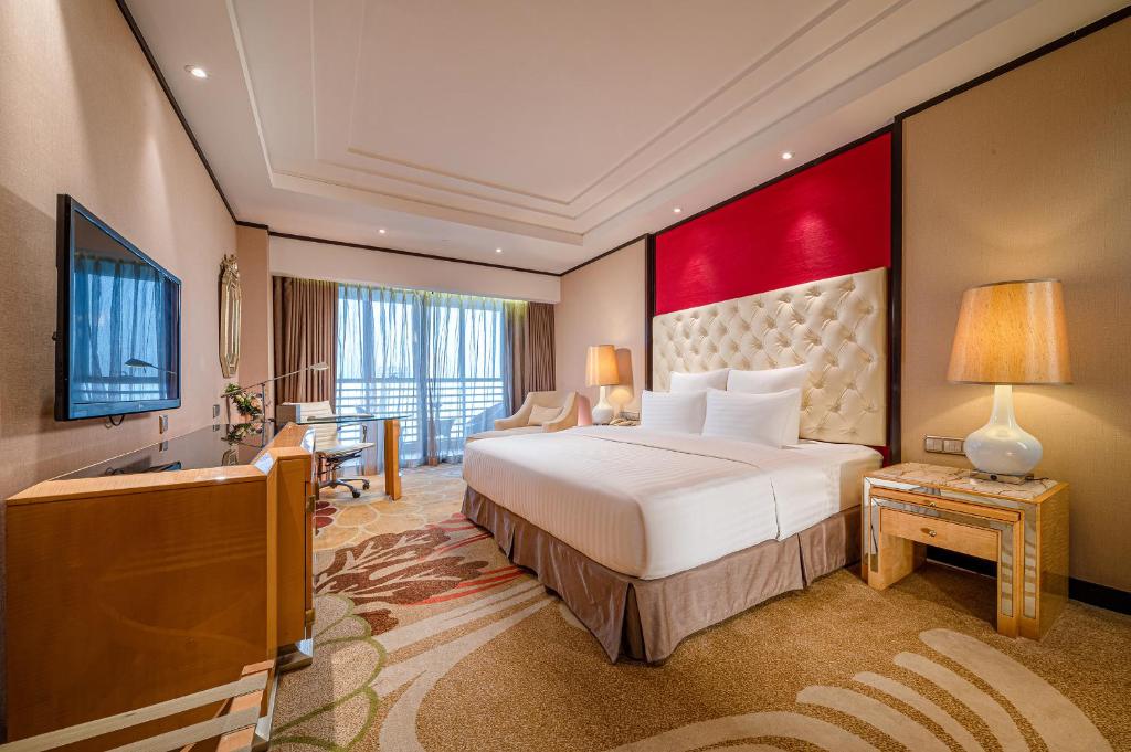 a hotel room with a large bed and a television at Nanning Landmark Hotel in Nanning