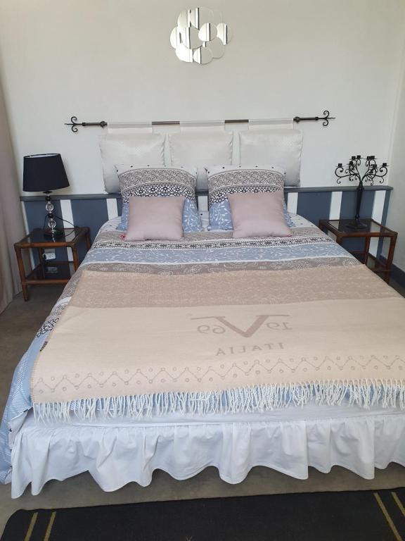 Una cama grande con almohadas rosas. en La Maison de Jeanne en Lesparre-Médoc