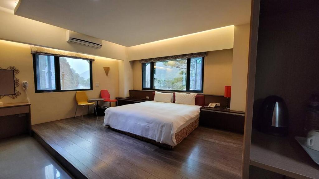 a bedroom with a large bed and two windows at Xiang Ting in Puli