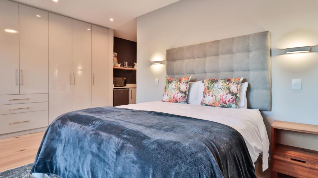 1 dormitorio con 1 cama grande y cabecero grande en @201 Golf Estate, en Mossel Bay