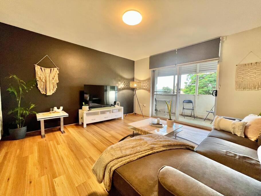 sala de estar con sofá y TV en Renovated Managers Apartment, en South Hedland