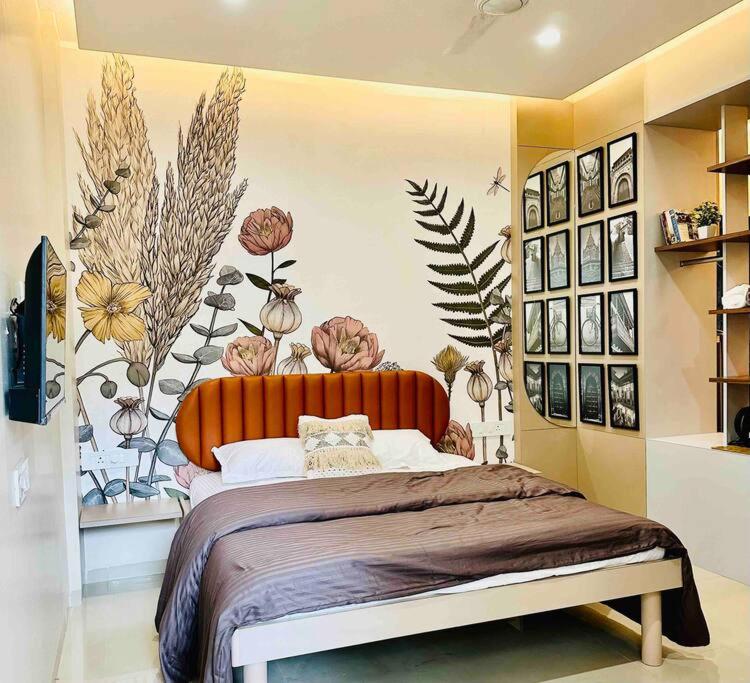 a bedroom with a large bed with flowers on the wall at Cozy Studio with Premium Interiors-WiFi,AC,SmartTv in Pune
