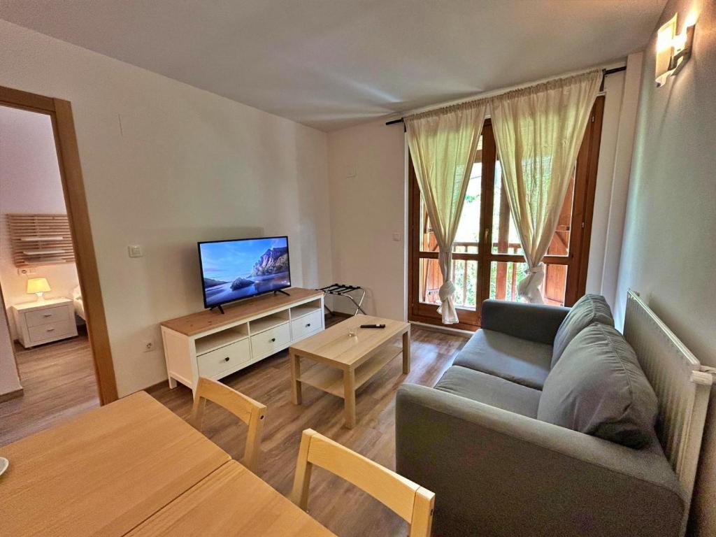 ein Wohnzimmer mit einem Sofa und einem TV in der Unterkunft Pleta de Soldeu 345 hasta 4 personas. in Canillo
