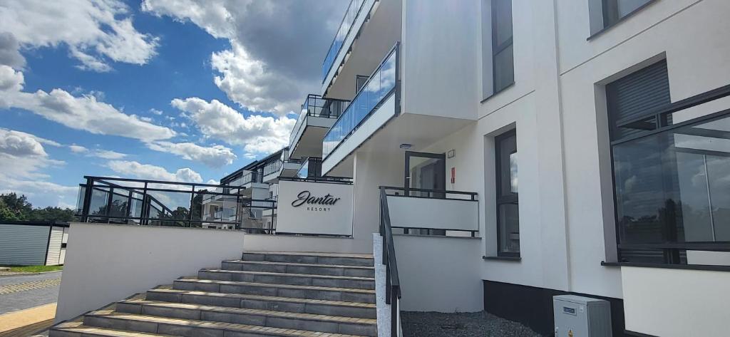 a white building with stairs in front of it at Apartament Bursztyn in Jantar