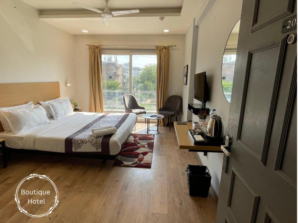 um quarto de hotel com uma cama e uma grande janela em Saltstayz Sector 39- Near Rajiv Chowk & Sohna Road em Gurgaon