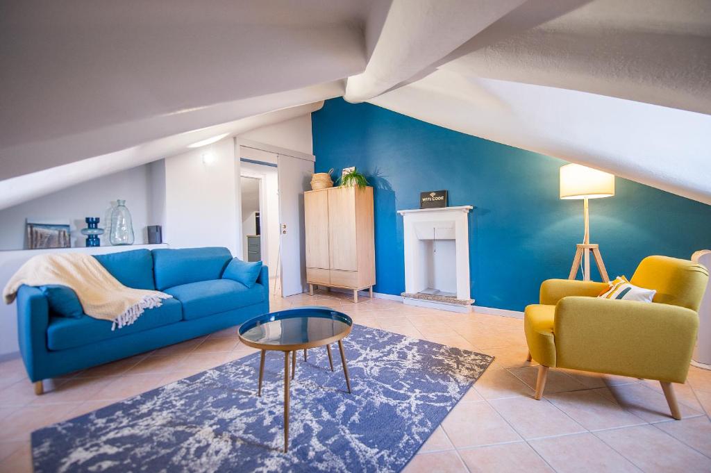 sala de estar con sofá azul y 2 sillas en Giolitti 39 - Moderna Mansarda nel cuore di Torino, en Turín