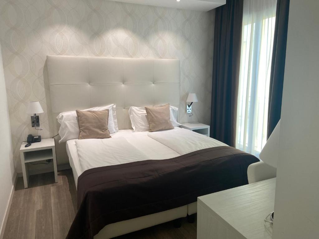 a bedroom with a large bed with a large headboard at International Beach Hotel in Caorle