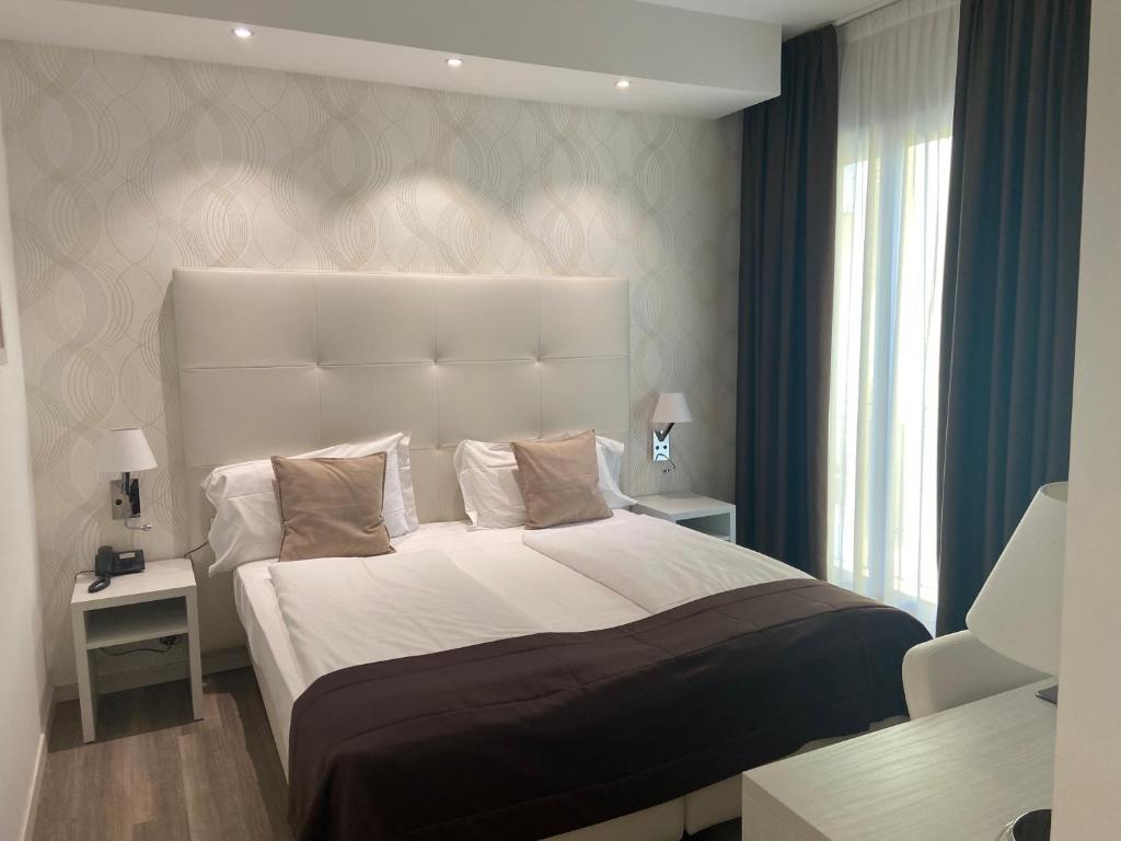 a bedroom with a large bed and a window at International Beach Hotel in Caorle