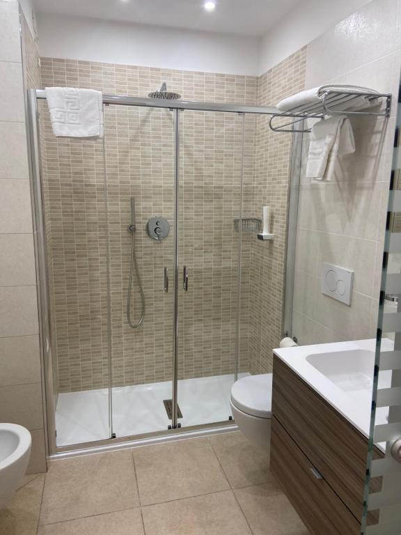 a bathroom with a shower with a toilet and a sink at International Beach Hotel in Caorle