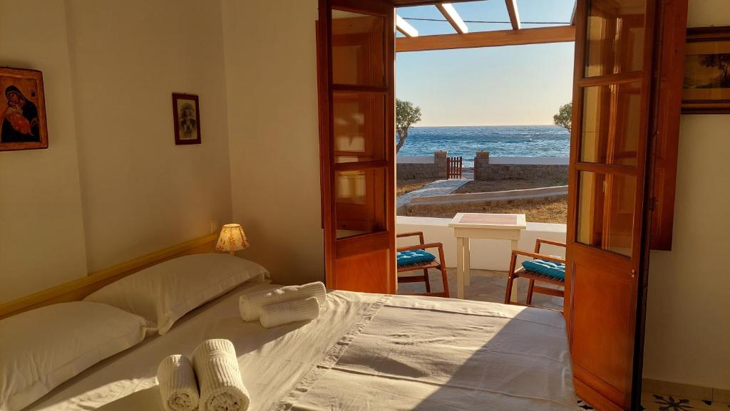 a bedroom with a bed and a view of the ocean at Villa Patmos Netia - Location Xoxlakas in Patmos