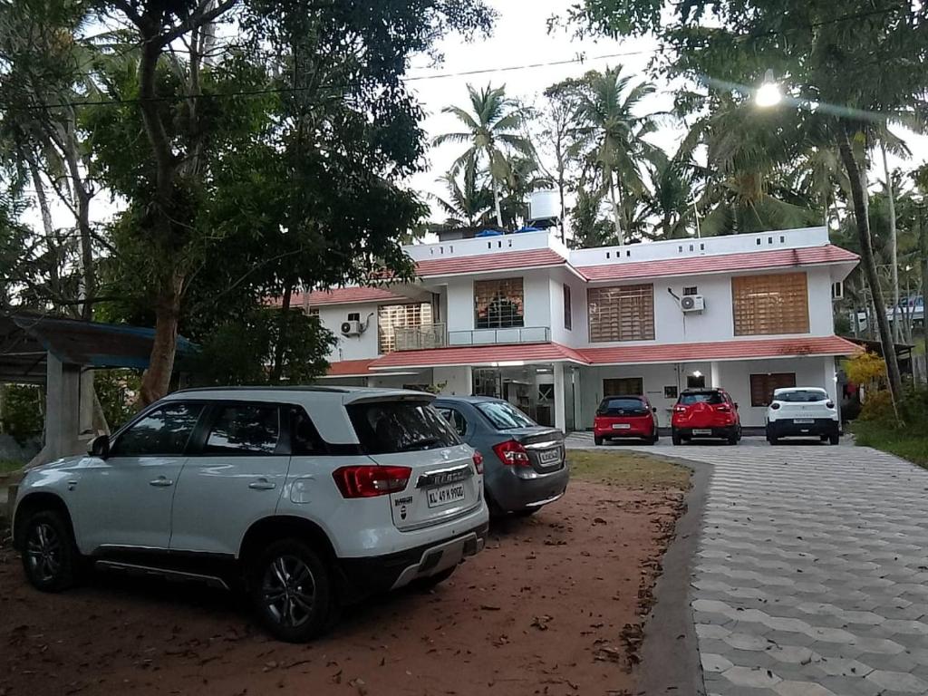 eine Gruppe von Autos, die vor einem Gebäude geparkt sind in der Unterkunft Somatheertham Ayurvedic Resort in Thiruvananthapuram