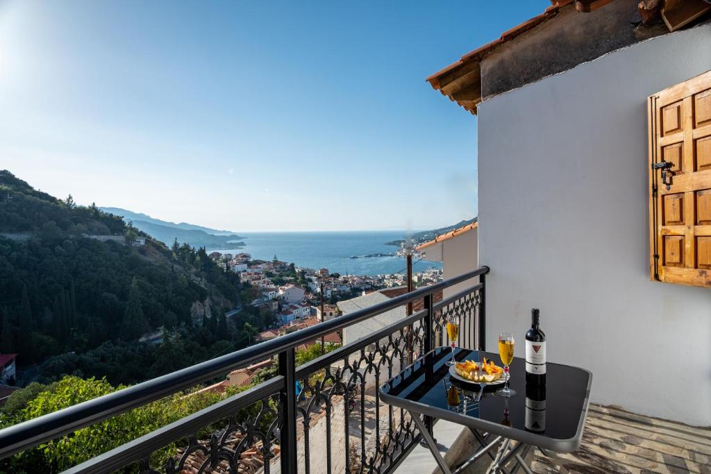 einen Balkon mit einem Tisch und einer Schüssel Essen in der Unterkunft Billy's Stonehouse in Samos