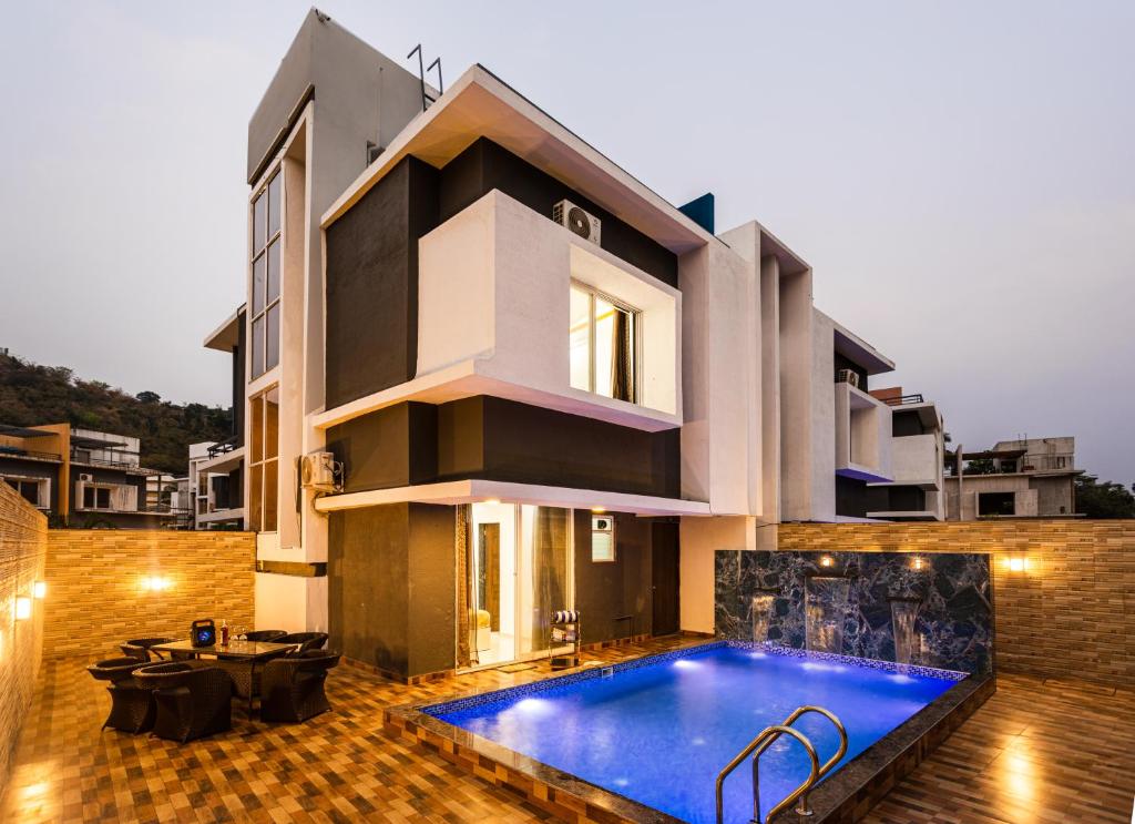 a house with a swimming pool in front of it at Denver Villa in Lonavala
