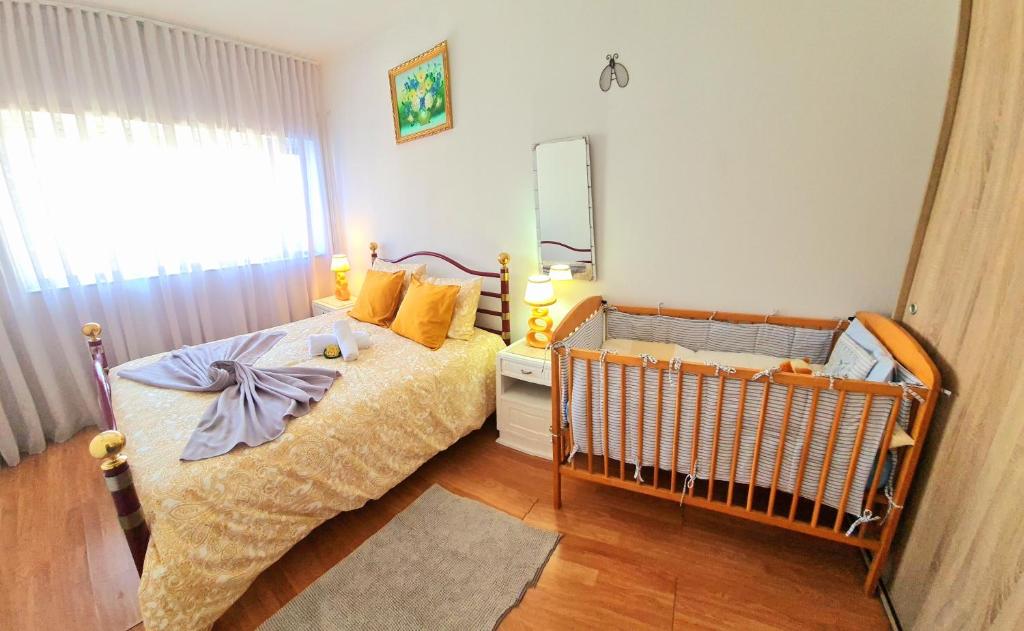 a bedroom with a crib and a large window at Station House in Braga