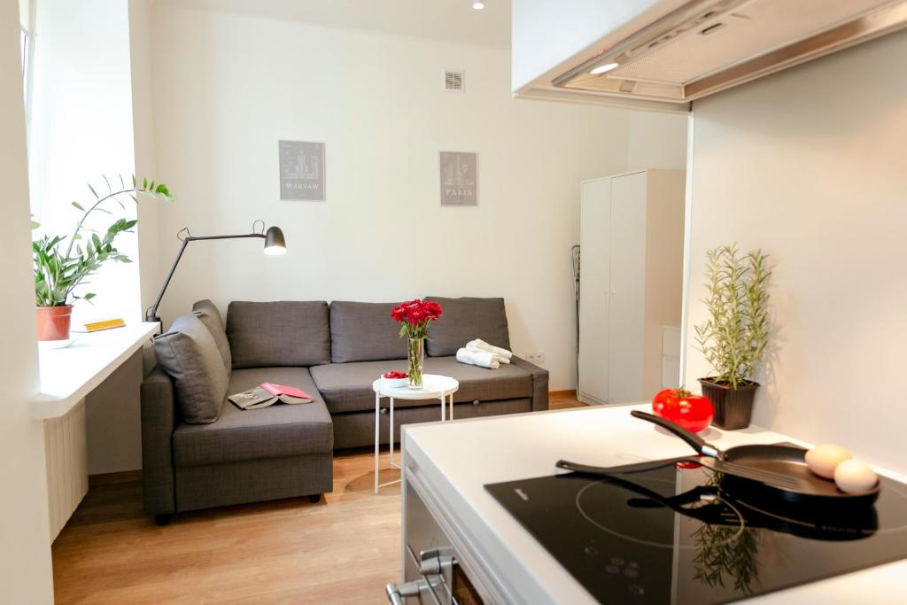 uma cozinha e uma sala de estar com um sofá em Jana Pawła II 36 - Bezpłatny podziemny garaż - Free Parking - W pełni wyposażone studio - Better Rental em Varsóvia