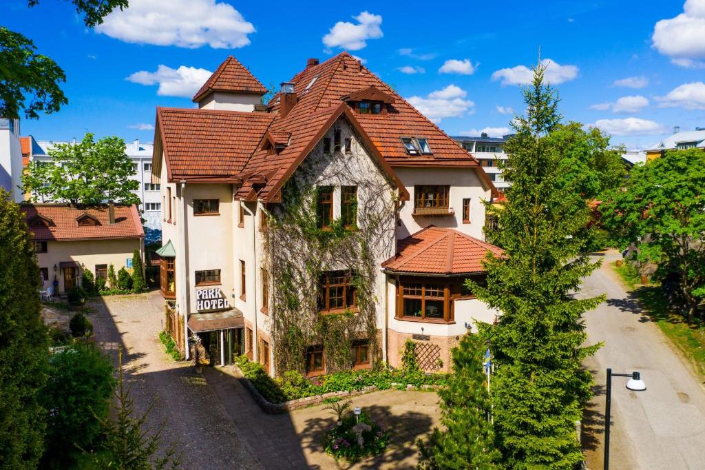 une grande maison avec un toit rouge dans l'établissement Park Hotel Turku, à Turku