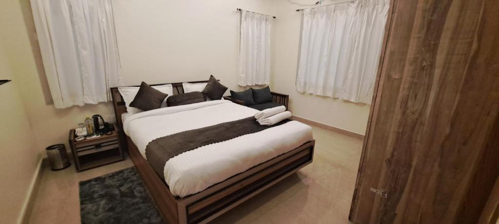 a bedroom with a bed with white sheets and black pillows at The Candy Studio in Rānchī