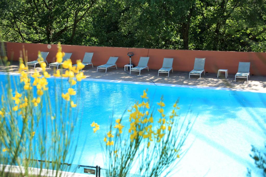 a group of chairs sitting next to a swimming pool at La Colline des Ocres Village de vacances 3 étoiles in Apt