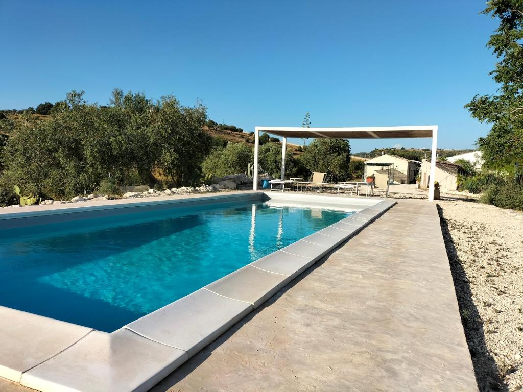 a swimming pool in a backyard with a gazebo at Casa Giufà B&B in Chiaramonte Gulfi